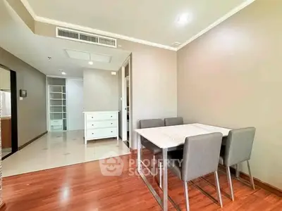 Modern dining area with sleek table and chairs, featuring hardwood floors and neutral walls.