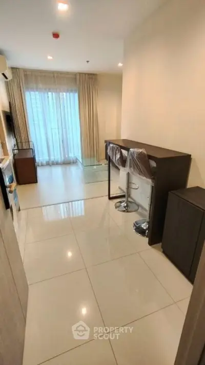 Modern living room with sleek tile flooring and stylish bar seating in a contemporary apartment.