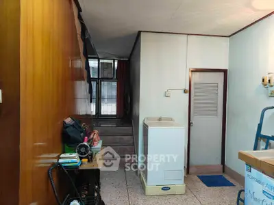 Cozy interior space with washing machine and staircase, ideal for practical living.