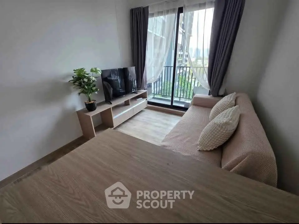 Cozy living room with balcony view, modern decor, and natural light