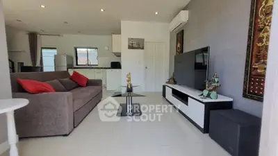 Modern living room with stylish decor, large TV, and comfortable seating in a bright, airy space.