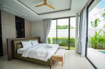 Luxurious bedroom with garden view and modern decor in a serene setting.