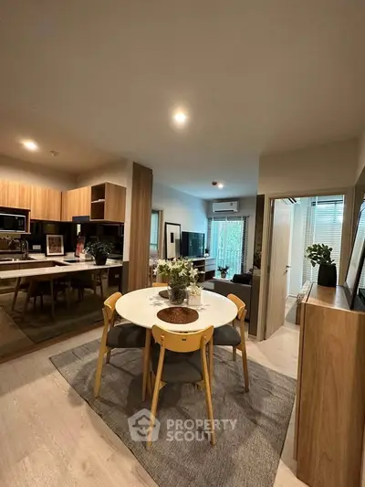 Modern open-plan kitchen and dining area with stylish wooden cabinets and contemporary decor.