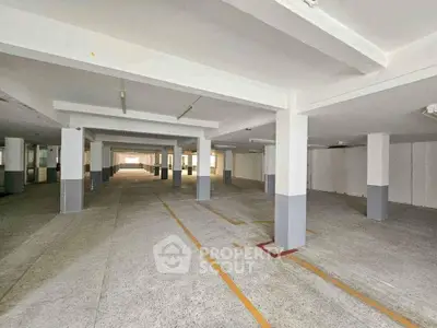 Spacious underground parking area with ample lighting and marked spaces.