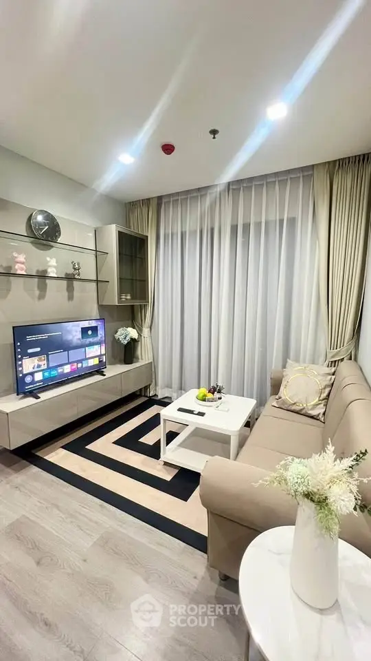Modern living room with sleek furniture and large TV, perfect for relaxation and entertainment.