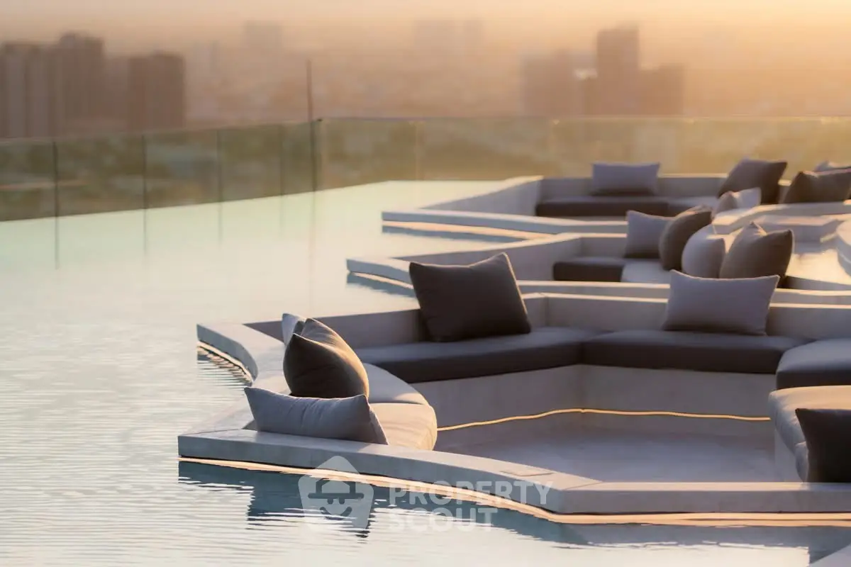 Luxurious rooftop pool with stylish seating and stunning city view at sunset.