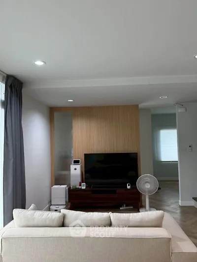 Modern living room with cozy sofa and entertainment center in stylish apartment.