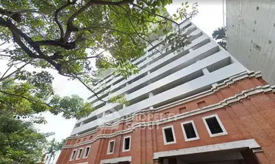 Stunning architectural building with red brick facade and lush greenery, perfect for urban living.
