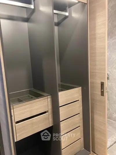 Modern walk-in closet with sleek wooden drawers and contemporary design.