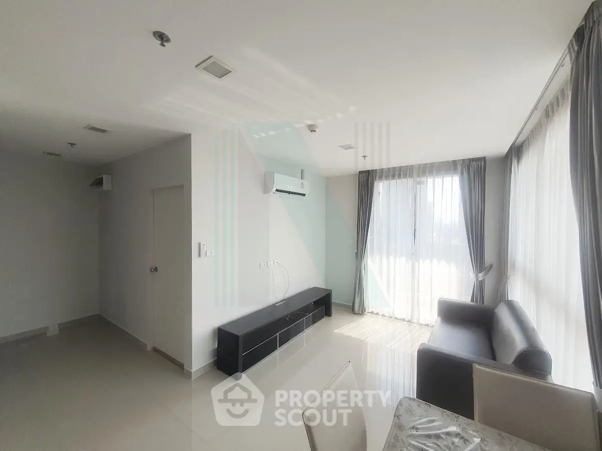 Spacious modern living room with large windows and sleek furniture, perfect for natural light lovers.