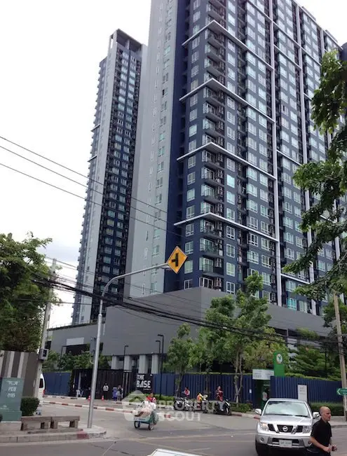 Modern high-rise condominium building with sleek design and urban surroundings.
