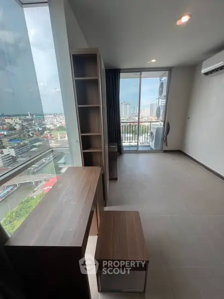 Modern high-rise apartment with stunning city view and balcony access.