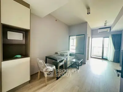 Modern living room with dining area and balcony access in a stylish apartment.