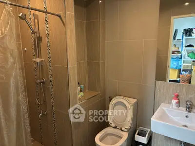 Modern bathroom with shower, toilet, and sink in stylish tile design.