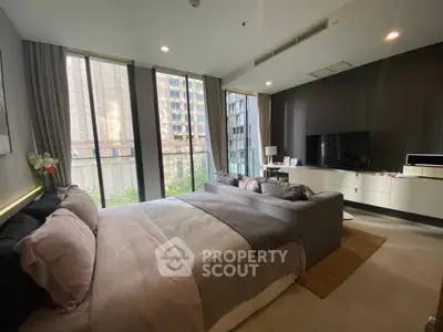 Luxurious modern bedroom with large windows and stylish decor in urban high-rise apartment.