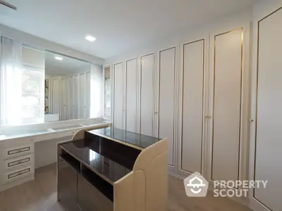 Luxurious walk-in closet with elegant cabinetry and natural light