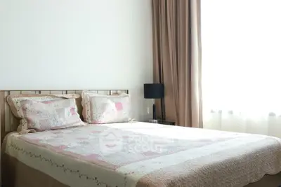 Cozy bedroom with soft lighting and elegant decor, featuring a comfortable bed and stylish curtains.