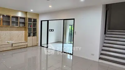 Spacious modern living room with sleek tile flooring and glass partition