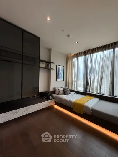 Modern bedroom with large windows and wooden flooring, featuring a cozy bed and stylish decor.