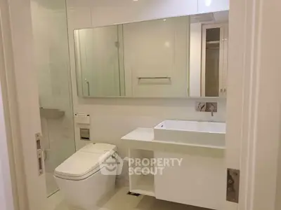 Modern bathroom with sleek fixtures and large mirror in a contemporary home.