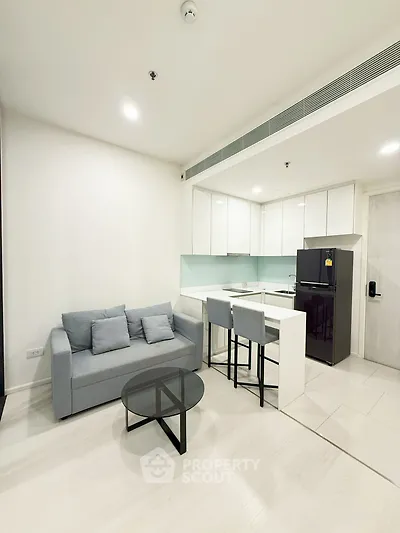 Modern open-layout living room with sleek kitchen and cozy seating area