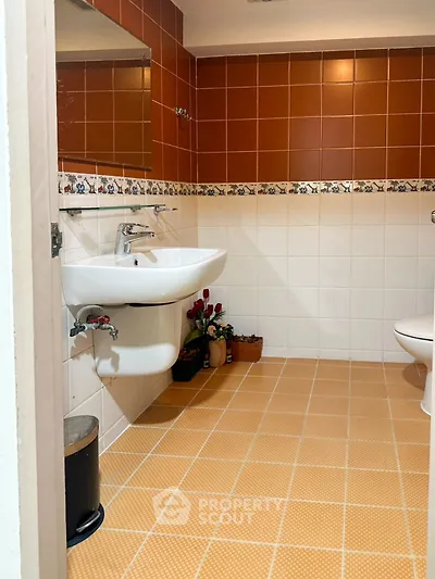 Charming bathroom with warm tiles and modern fixtures, perfect for relaxation.