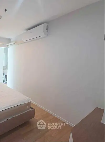 Modern minimalist bedroom with air conditioning and wooden flooring