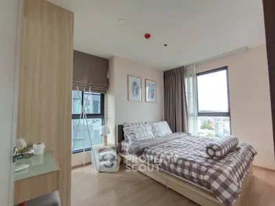 Cozy bedroom with modern decor and large windows offering natural light and city views.