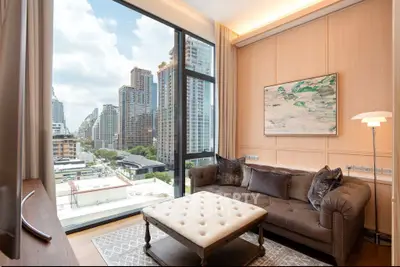 Luxurious living room with stunning city view, elegant sofa, and large window in modern high-rise apartment.