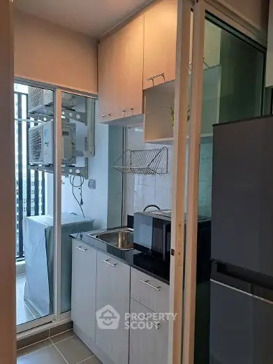 Compact kitchen with modern appliances and balcony view