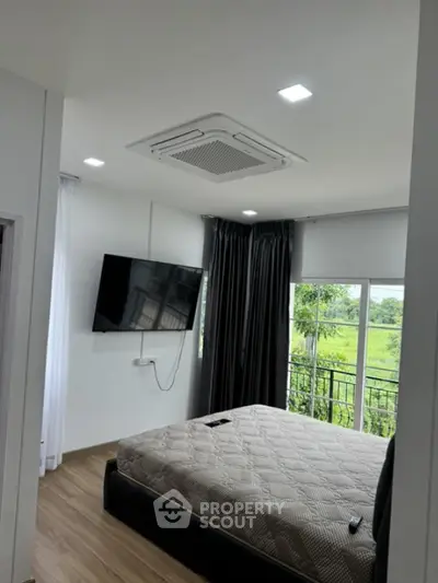 Modern bedroom with wall-mounted TV and scenic window view