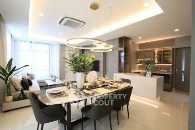Luxurious open-plan living and dining area with modern decor and elegant lighting.