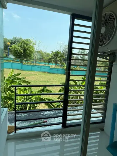 Charming balcony with lush garden view and modern railing design, perfect for relaxation and outdoor enjoyment.