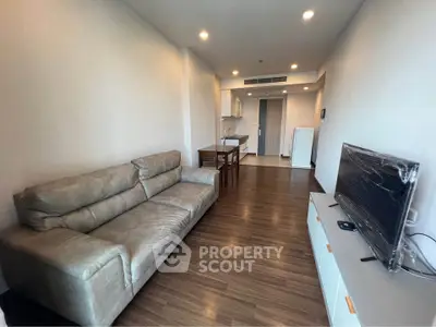 Spacious living room with modern furniture and open kitchen layout in a stylish apartment.