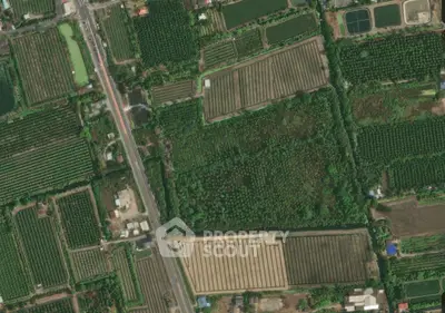 Aerial view of expansive agricultural fields and surrounding greenery, showcasing rural landscape and farmland layout.