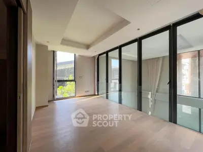 Spacious modern living room with floor-to-ceiling windows and hardwood flooring