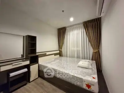 Modern bedroom with stylish furniture and large window, perfect for comfort and relaxation.