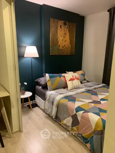 Cozy bedroom with modern decor and geometric bedding in a stylish apartment.