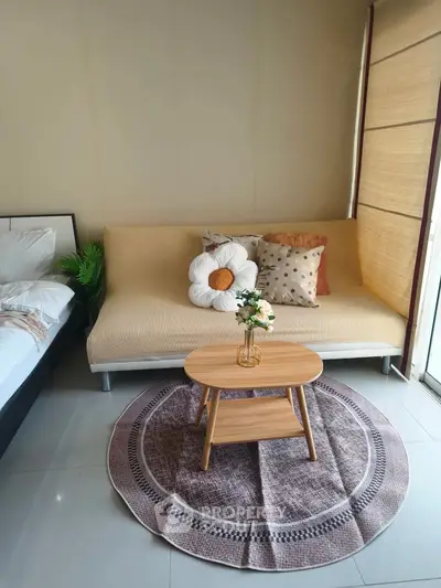 Cozy living room with stylish sofa, decorative pillows, and a chic coffee table on a patterned rug.