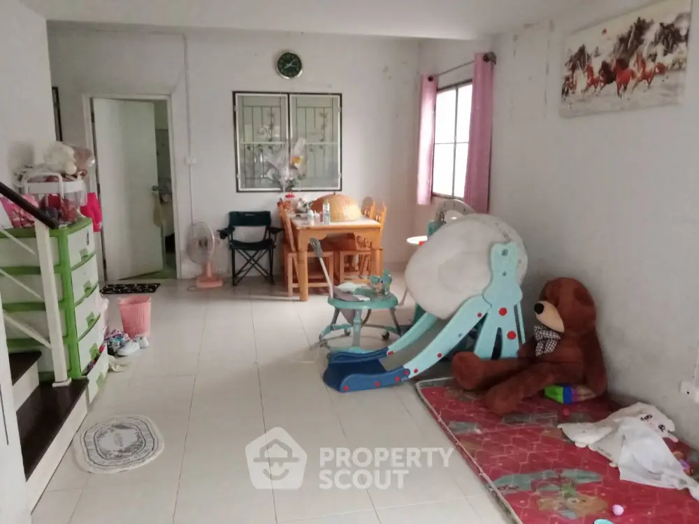 Spacious family-friendly living room with play area and dining space