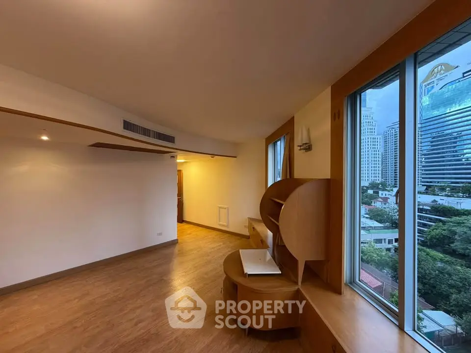 Spacious modern living room with large windows offering stunning city views.