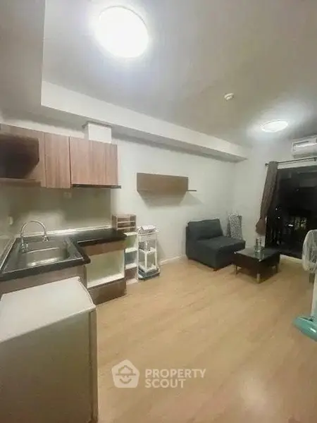 Cozy open-layout living room with modern kitchen and wooden flooring