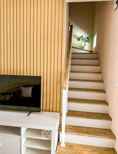 Modern interior with stylish staircase and TV unit, perfect for contemporary living.
