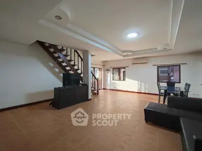 Spacious living room with modern staircase and ample natural light