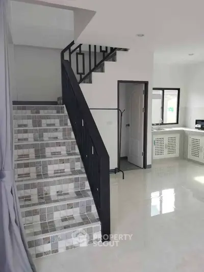 Modern interior with stylish staircase and sleek kitchen design