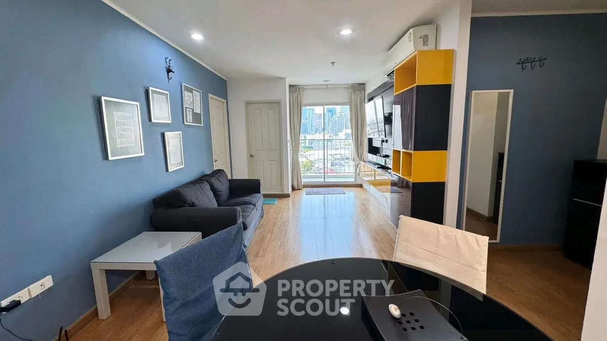 Modern living room with city view, stylish decor, and open layout in a high-rise apartment.