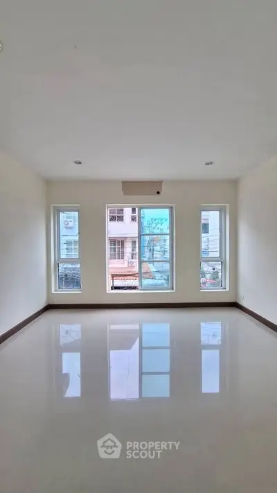 Spacious empty room with large windows and glossy floor, perfect for customization.