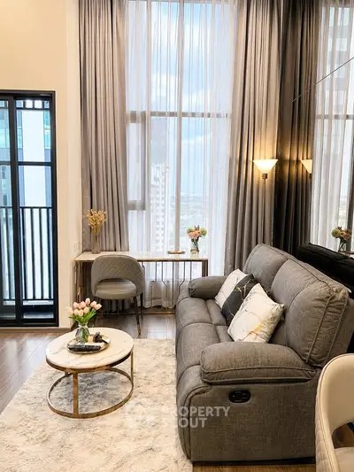 Luxurious living room with elegant decor and floor-to-ceiling windows offering stunning city views.