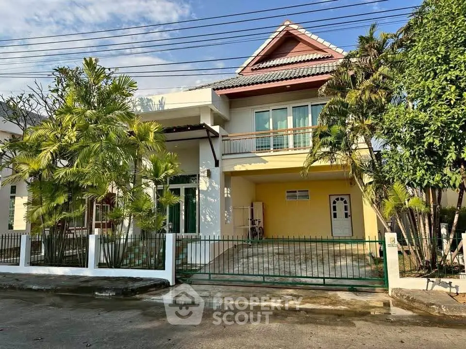 Charming two-story house with lush greenery and spacious driveway in a serene neighborhood.