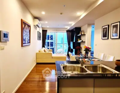 Modern open-layout living room with kitchen island and city view, perfect for urban living.